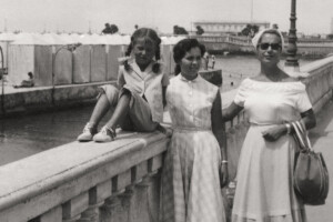 橋を背に女性と女の子がバッグを持ち並んでいる