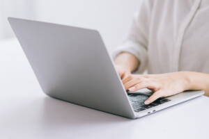 女性がパソコンにテキストを打ち込んでいる